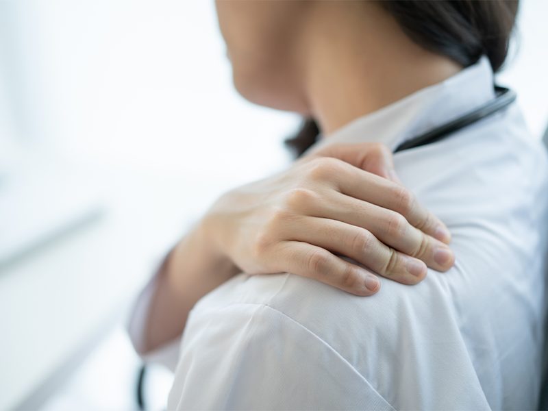 woman holding shoulder in pain
