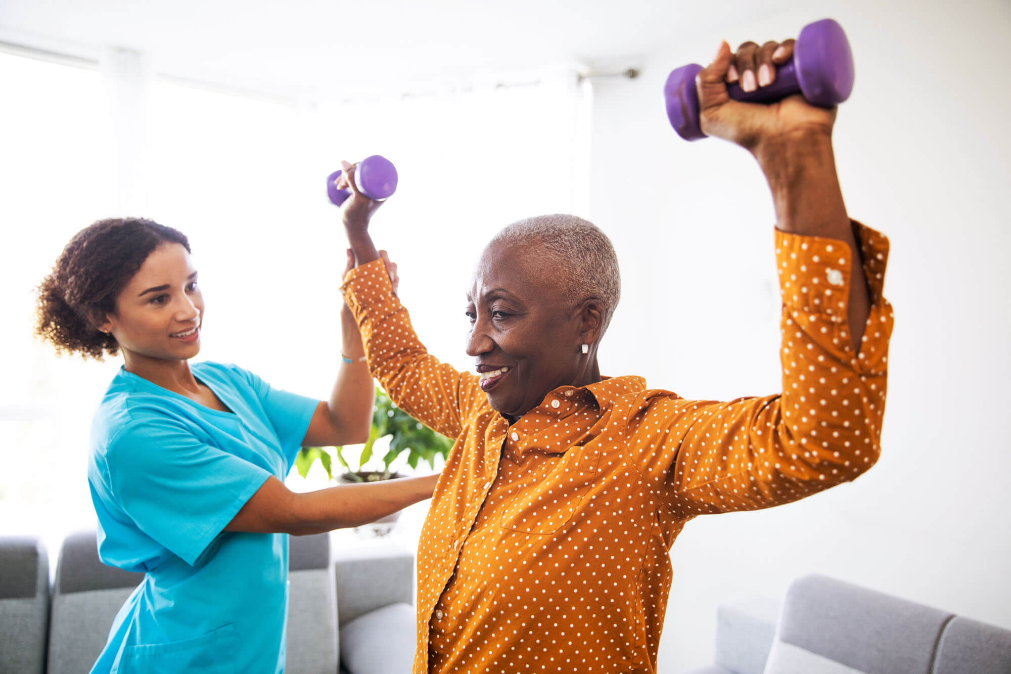 Older woman doing physical therapy with a healthcare worker
