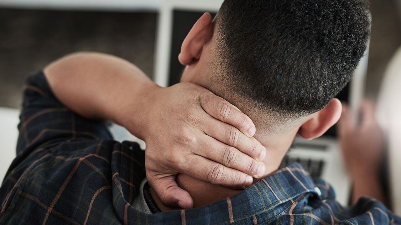 Man rubbing neck from pain