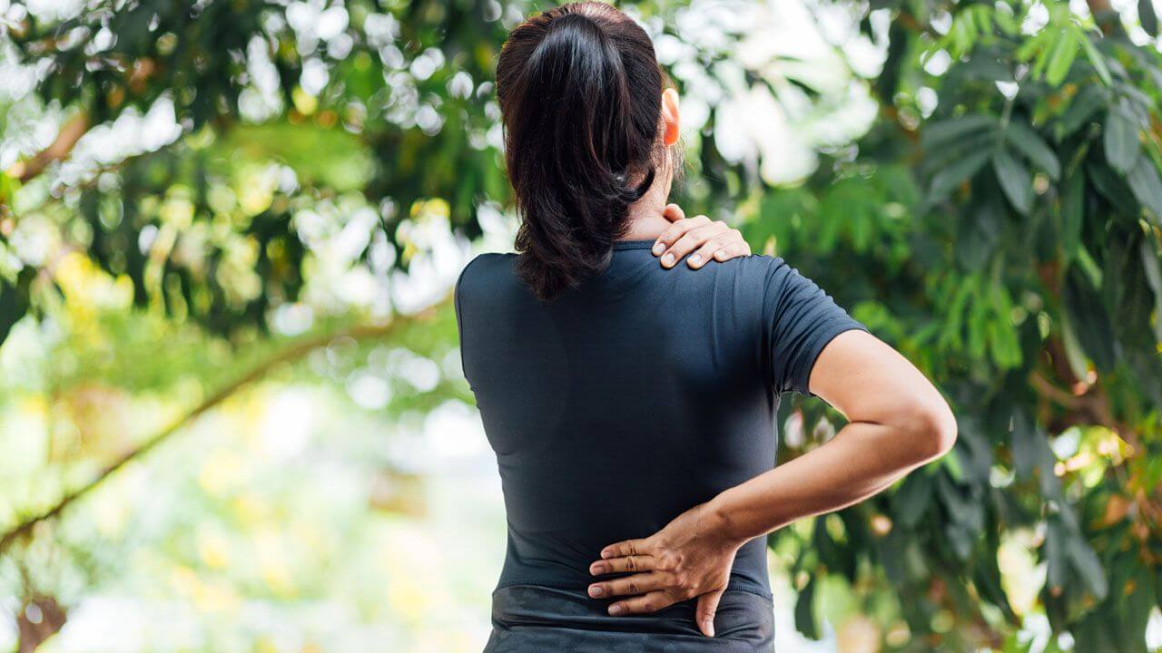 A woman holding her back in pain.