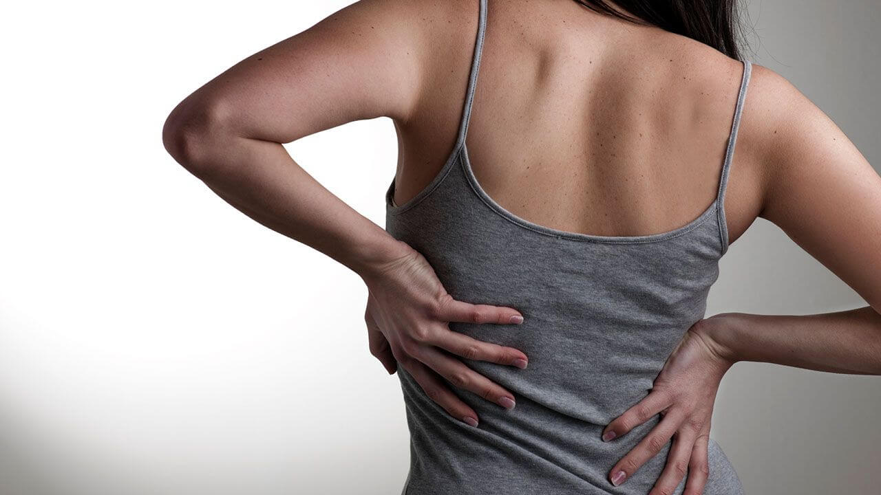 Woman holding her back due to back pain