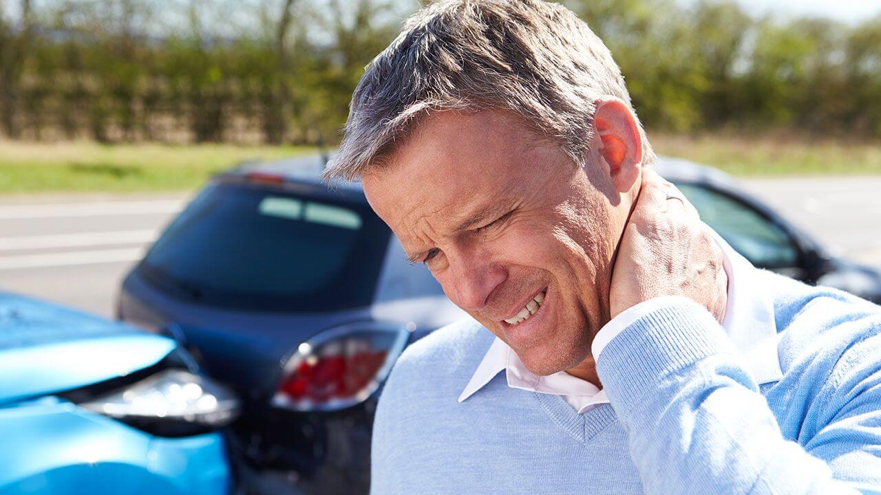 Man rubbing his neck in pain after being in an auto accident