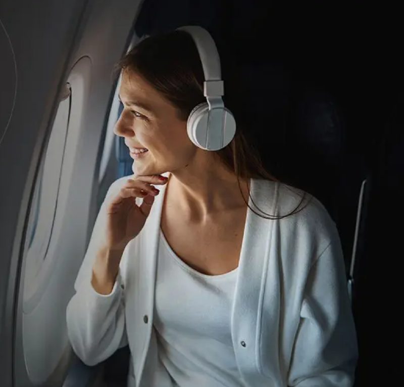 Smiling woman looking out airplane window